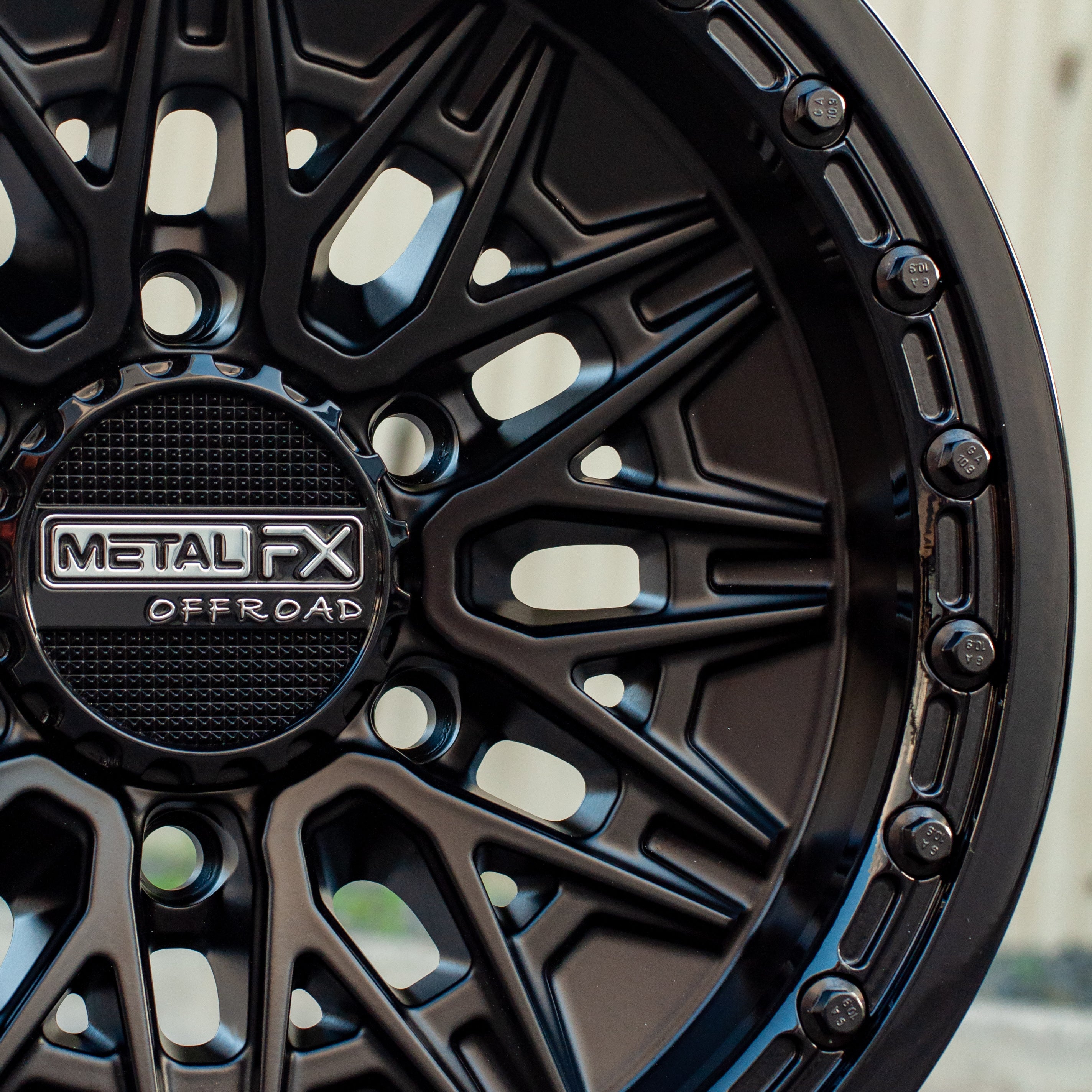 Close-up of Alpha 6R beadlock wheels featuring a Satin Black finish and Gloss Black ring design.